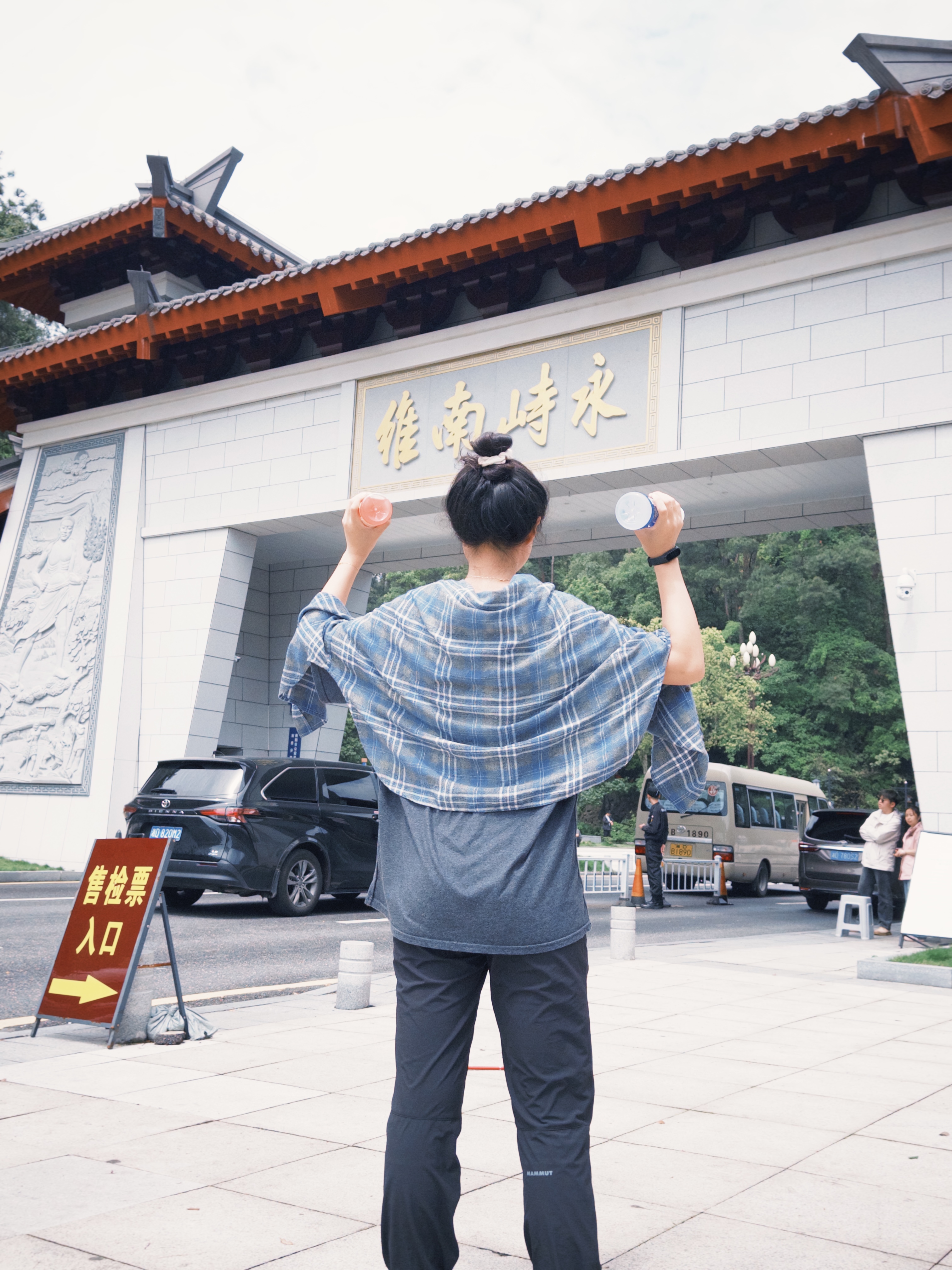 简老师在旅途中举起饮料瓶